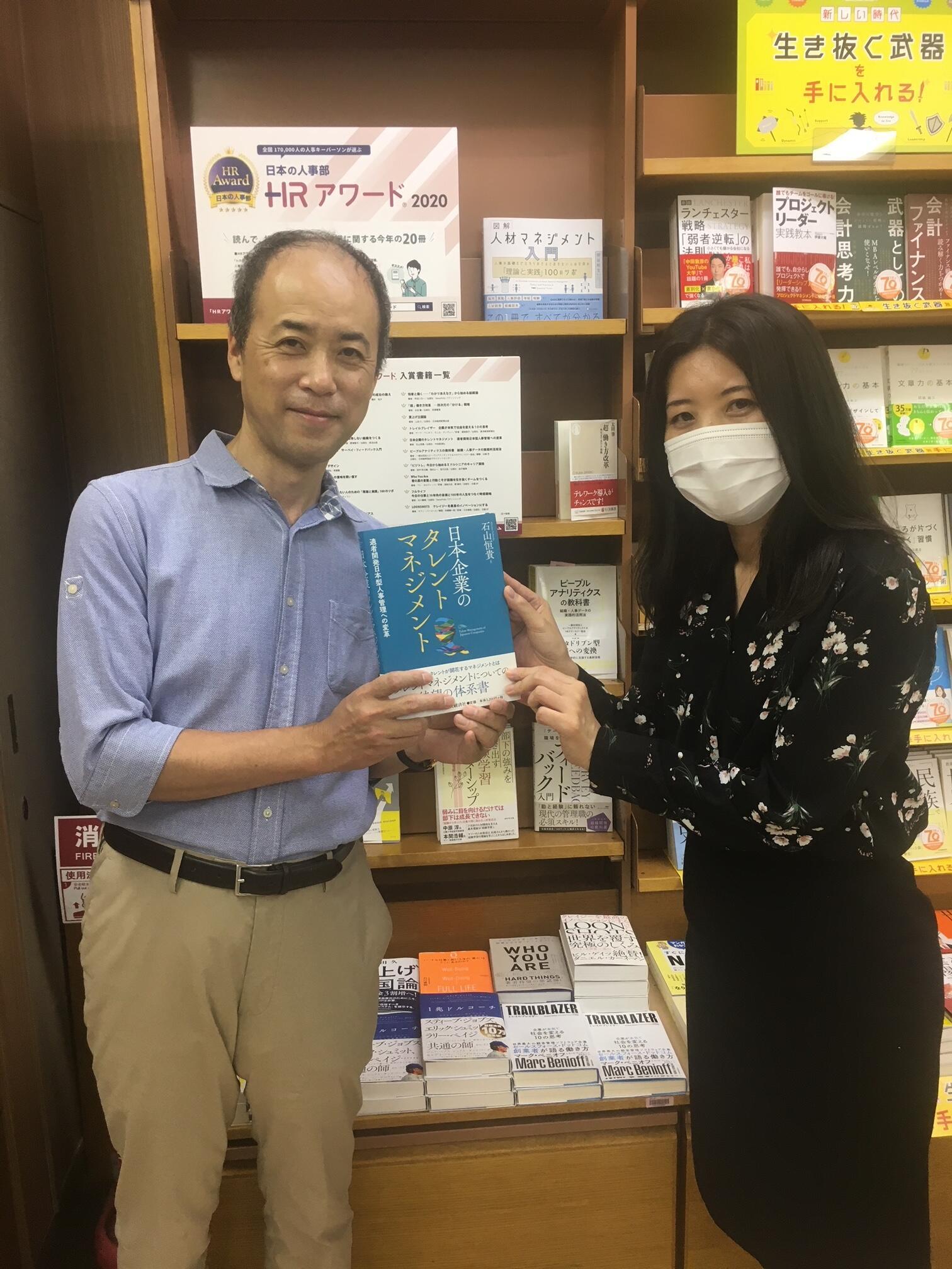 紀伊國屋書店大手町店さんでの「HRアワード2020」フェアの棚の前で撮影された石山先生と担当編集者の写真